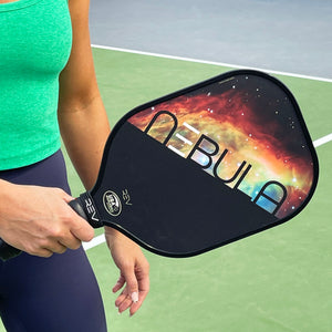 Close-up of a player gripping the USAPA-approved REV NEBULA pickleball paddle on the court